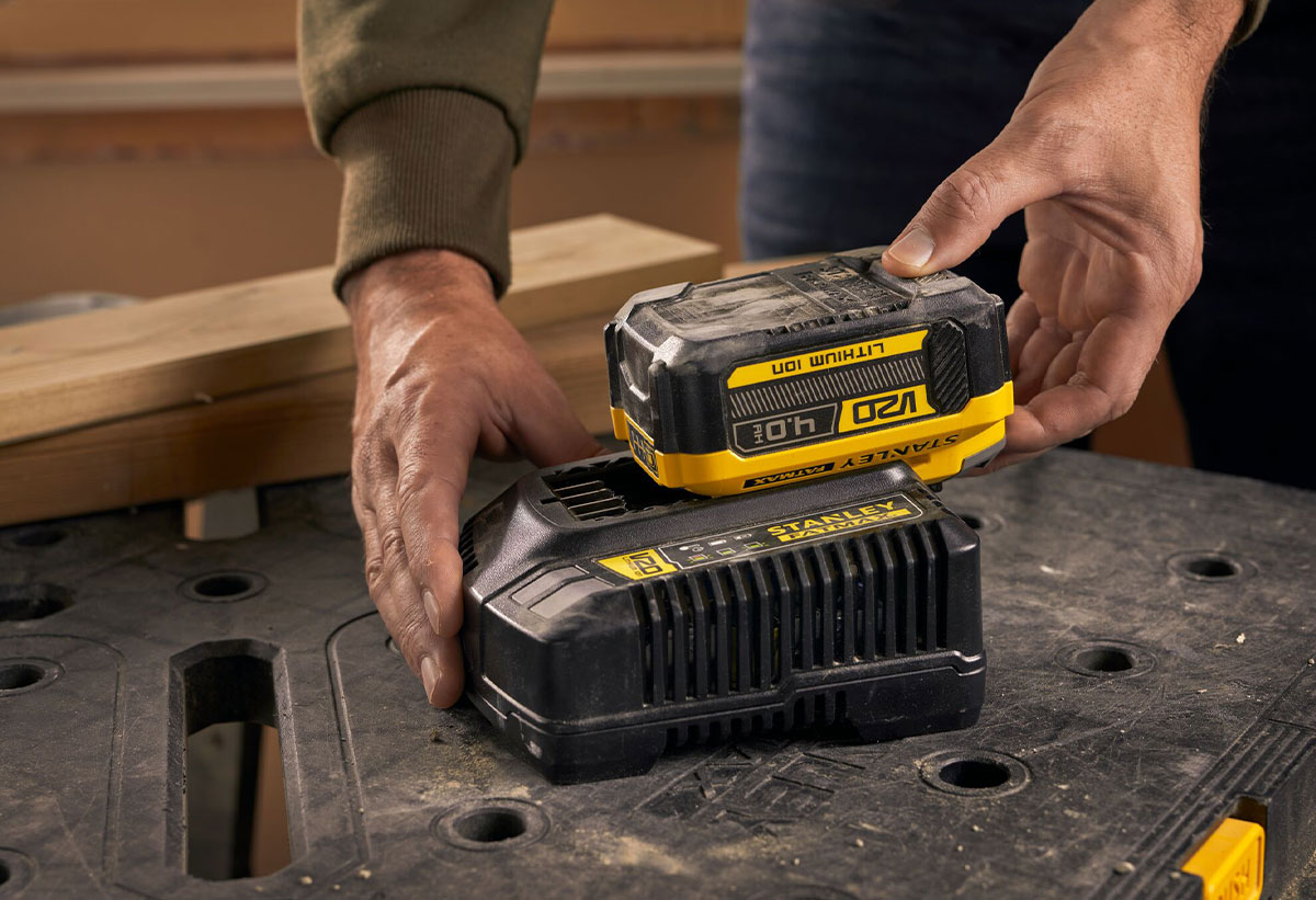 Απεικονίζεται η μπαταρία να τοποθετείται στον φορτιστή για φόρτιση.